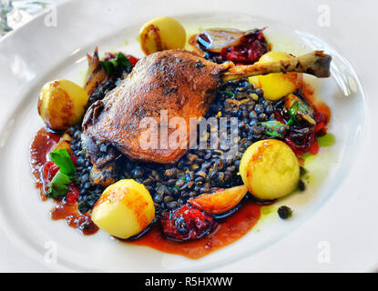 Cuisse de canard aux lentilles dans une assiette blanche Banque D'Images