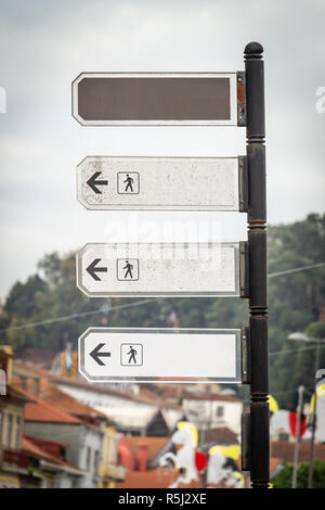 Pôle bronze vertical avec trois panneaux de direction blanche vide avec les distances de marche et un brown signe vide. Copier l'espace. Immersive. Banque D'Images
