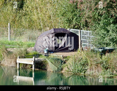 Pêche en eau douce à un lac avec tente camouflée, Royaume-Uni en octobre Banque D'Images