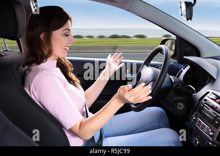 Vue latérale d'une jeune femme assise à l'intérieur de l'auto voiture conduite Banque D'Images