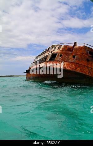 Épave rouillée sur le côté dans les eaux des Caraïbes dévastée par un ouragan Banque D'Images