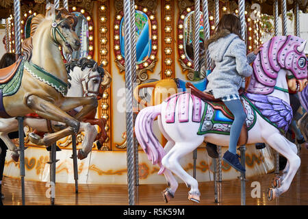 Peu de filles de retour sur un carrousel Banque D'Images