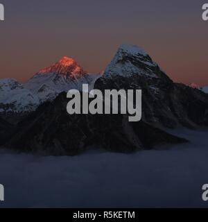 La lumière du soleil dernière du jour illuminent le Mt Everest. Mer de brouillard. Banque D'Images