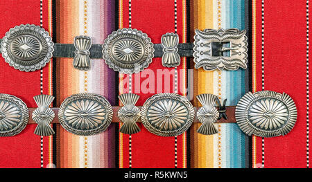 L'Argent Sterling Native American Concho sur ceinture tissu imprimé de couleur vive le sud-ouest. Banque D'Images