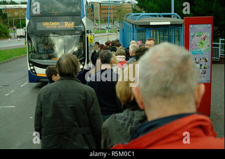 Les gens attendent à bord d'un parc-relais bus en centre-ville. Banque D'Images