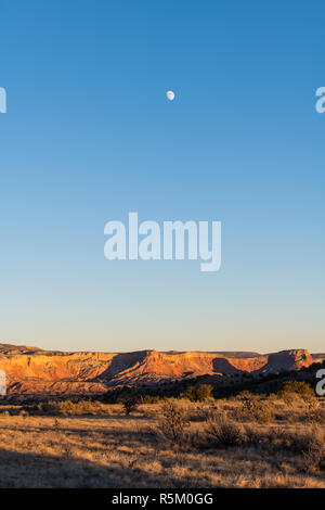 Lune au-dessus d'un paysage de désert coloré au crépuscule sur Ghost Ranch à Abiquiu, Nouveau Mexique Banque D'Images