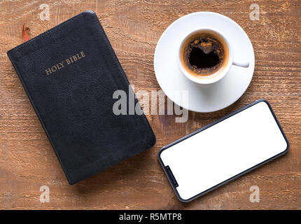 Sainte Bible et smartphone avec la tasse de café noir Banque D'Images
