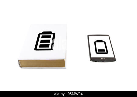 Comparaison d'un smartphone et un livre isolé sur blanc. Concept de vie de la batterie. Banque D'Images