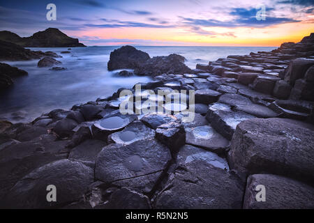 Coucher de soleil sur la formation des roches Giants Causeway, comté d'Antrim, en Irlande du Nord, Royaume-Uni Banque D'Images