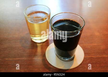 Café noir chaud chaud et thé Chinois dans verres transparents servi sur table en bois Banque D'Images