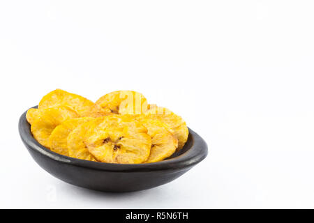 Le plantain poêlée de pièces dans une cuvette d'argile noir traditionnel isolé sur fond blanc Banque D'Images