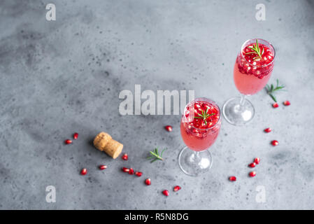 Champagne Cocktail Grenade Mimosa (cocktails sans alcool) au romarin sur fond de béton, de copier l'espace. Mimosa boisson pour la Saint-Valentin ou autres jours fériés. Banque D'Images