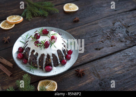 Le pudding de Noël, fruits gâteau décoré avec du glaçage et des canneberges sur table en bois rustique, de copier l'espace, vue d'en haut. Noël traditionnel fait maison desser Banque D'Images