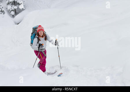 Femme skitur skieur freerider en amont dans la neige en forêt d'hiver Banque D'Images