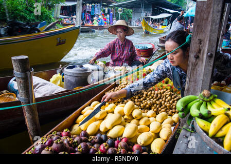 Vendeur de fruits et de noix de coco fraîche crêpes au marché flottant de Damnoen Saduak en Thaïlande. Banque D'Images