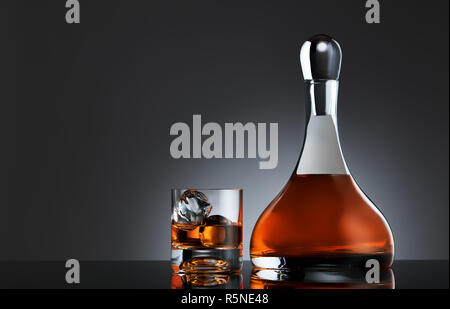Verre de whisky avec de la glace et une carafe ronde pleine de whisky single malt. Moody tourné élégant. Banque D'Images