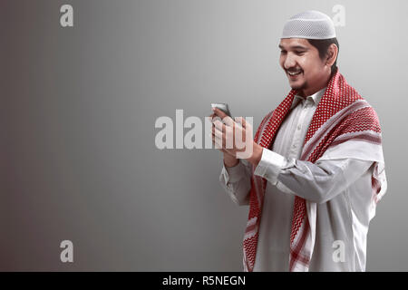 Muslim man holding cellphone Banque D'Images