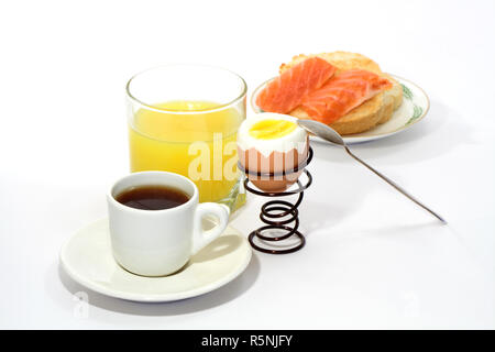 Nature morte avec du jus de fruit, café, oeuf mollet et sandwich poisson isolé sur fond blanc Banque D'Images