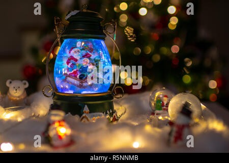 Scène de Noël, le Père Noël avec les enfants sur un traîneau dans la neige, les rennes, les ours polaires et les bonshommes de dômes et des bougies, sapin Noël en Banque D'Images