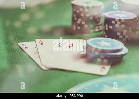 Casino, paris sportifs, concept. Quatre as et des jetons de poker sur feutre vert abstract background Banque D'Images