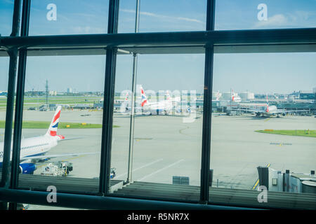 Le 24 septembre, 2017 Londres/UK - En regardant à travers les grandes fenêtres de la borne 5 pour les avions stationnés à l'extérieur, l'aéroport de Heathrow Banque D'Images