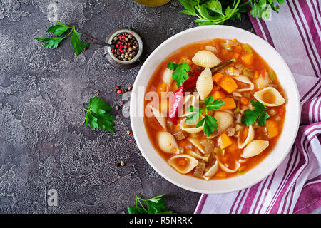 Minestrone, soupe de légumes avec des pâtes italiennes sur table. La nourriture végétalienne. Vue d'en haut Banque D'Images