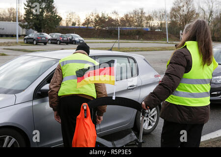 Lauterbourg, France. 06Th Nov, 2018. Parler aux manifestants les conducteurs passant par le passage de la frontière allemande en français. Un manifestant allemand porte un drapeau allemand. Autour de 100 militants français gilet jaune a protesté contre l'Allemand Français de passage frontalier à Lauterbourg contre le gouvernement français et l'augmentation de la taxe sur les carburants. Ils étaient secondés par environ 30 militants de l'extrême droite allemande Women's Alliance Kandel. Ils faisaient partie des plus gros mouvement de protestation gilet jaune en France. Crédit : Michael Debets/Pacific Press/Alamy Live News Banque D'Images