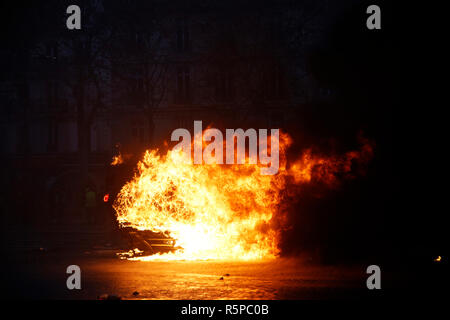 Paris, France. 1er décembre 2018. . La lumière des manifestants une voiture en feu au cours d'une manifestation de la yellow jackets. Credit : ALEXANDROS MICHAILIDIS/Alamy Live News Banque D'Images