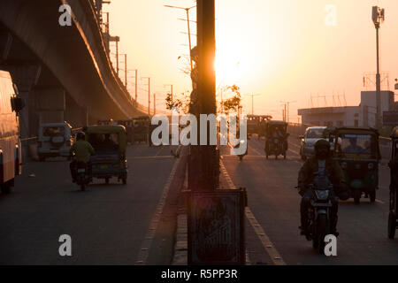 Pousse-pousse et de trafic automobile sur passage supérieur au coucher du soleil à Jaipur, Rajasthan, Inde Banque D'Images