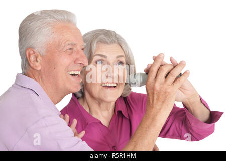 Senior couple singing karaoke sur fond blanc Banque D'Images