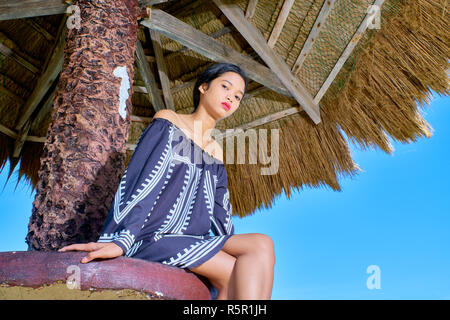 Beautiful woman posing - à bas l'appareil photo, sitting on table Banque D'Images