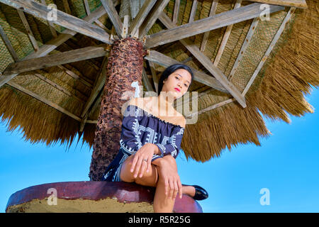 Beautiful woman posing - jambe et bras croisés croisés avec visage triste Banque D'Images