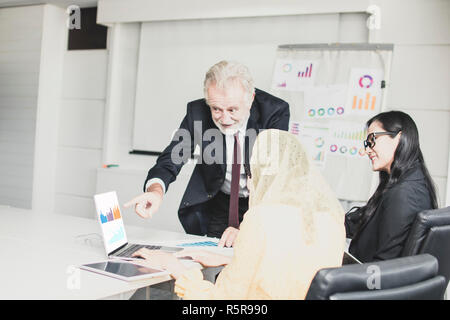 Big Boss, heureux ancien manager à la pointe et de travailler sur l'ordinateur portable de l'employé entre parler, rabotage et de brain storming comme répondant Banque D'Images