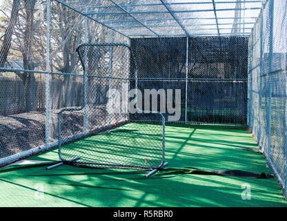 La vue depuis l'intérieur d'une cage au bâton de baseball de derrière l'écran de tangage Banque D'Images