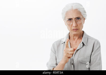 Je vous défends. Portrait de stricte et sérieuse déçu : granny avec cheveux blancs dans les verres de froncer avec mad expression shaking index dans grondent Banque D'Images