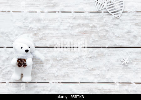 Les flocons de neige, coeur et l'ours en peluche sur la table en bois, flocons blancs de neige sur la lumière 24, Noël joyeux noël vacances ou saint Valentin romantique backgroun Banque D'Images