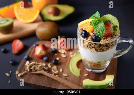 Granola, yogourt et fruits sur la garniture en verre sur la table en bois, des aliments sains pour le régime alimentaire concept Banque D'Images