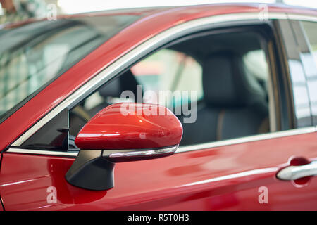 Close up de véhicule merveilleux rouge isolé dans le salon permanent. Intérieur cuir avec modèle incroyable attente nouveau propriétaire. Exemple de luminosité et le saturaled auto couleur. Cocept de vie de luxe. Banque D'Images