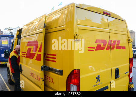 Gros plan de la fourgonnette jaune DHL Delivery et du chauffeur qui déchargent les colis Banque D'Images