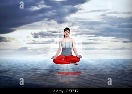 Asian woman doing yoga sur la mer Banque D'Images