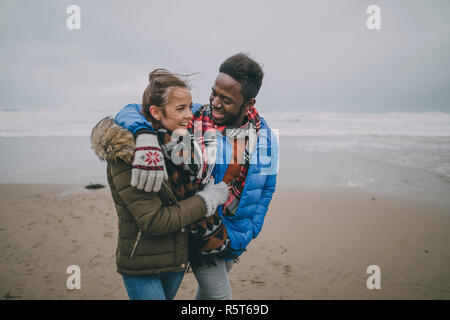 Jeune couple à pied le long de la plage d'hiver Banque D'Images