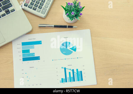 Ordinateur portable et graphique Vue de dessus, des tableaux, des diagrammes sur le bureau. Banque D'Images