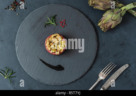 Tartare de boeuf cornichon et champignons marinés sur fond marbre sombre. Banque D'Images