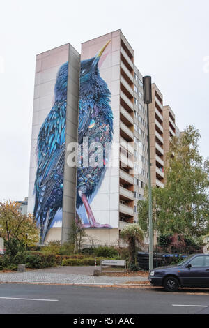 Berlin, Tegel Art Park. Art de rue, le starling géant avec plumes brillantes & poitrine de gems & vignes sur l'immeuble. Partie de projet Nation urbaine Banque D'Images