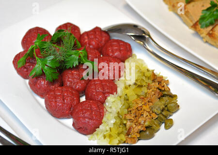 Tartare de boeuf cornichon, champignons marinés et oignon frais sur la plaque. Banque D'Images