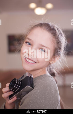 Fille avec un appareil photo rétro fait une photo, studio shot. Banque D'Images