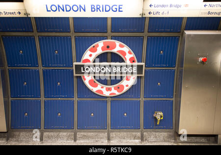 La station de métro de Londres signe à London Bridge, Jubilee Line, commémorant centenery de WW1 avec red poppies dans logo cocarde. Banque D'Images