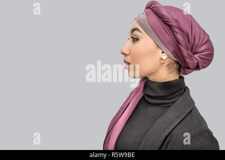 Plan de profil de jeune femme arabe en hijab. Elle est seul. Isolé sur fond gris Banque D'Images