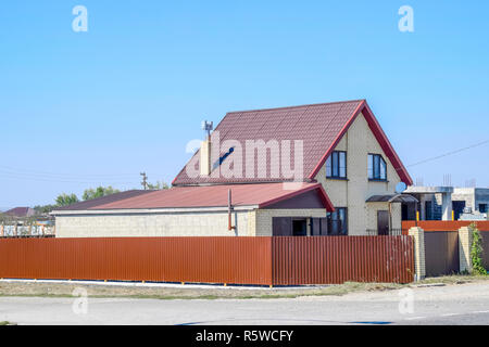 Chambre avec fenêtres en PVC et toiture de tôle ondulée. Roofing d'un profil en métal de forme ondulée sur la chambre avec fenêtres en plastique Banque D'Images