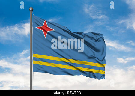 Drapeau d'Aruba dans le vent contre blanc nuageux ciel bleu. Banque D'Images